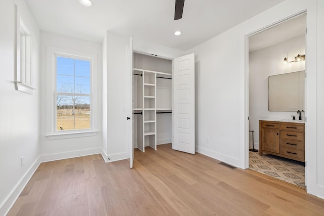 998 Iron Hill Rd, Burns, TN 37029 - unfurnished bedroom with light wood finished floors, visible vents, a sink, ensuite bath, and baseboards