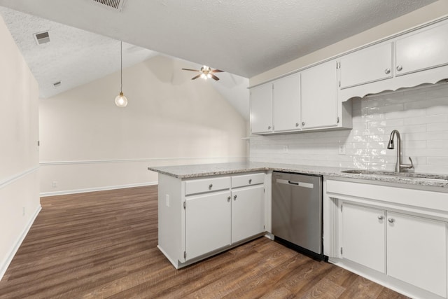 kitchen featuring dark wood-style floors, a ceiling fan, a sink, dishwasher, and a peninsula