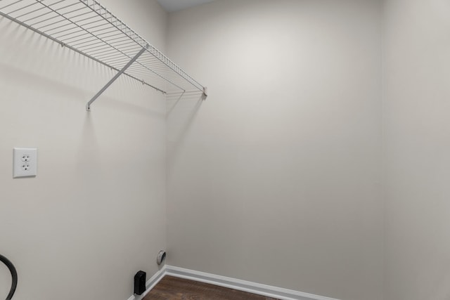 laundry room featuring dark wood-type flooring, laundry area, and baseboards