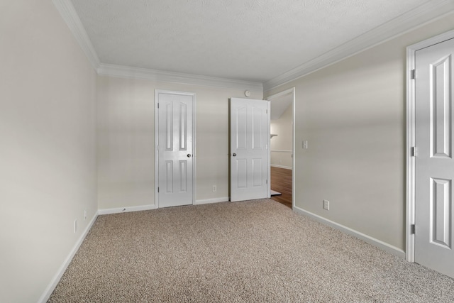 unfurnished bedroom featuring crown molding, a textured ceiling, baseboards, and carpet flooring