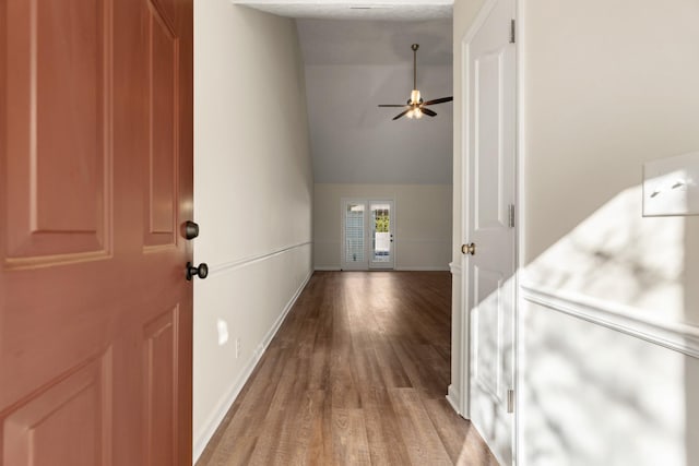 corridor featuring light wood-style floors and baseboards