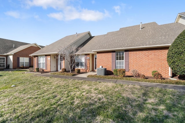 back of house with a yard, brick siding, roof with shingles, and cooling unit