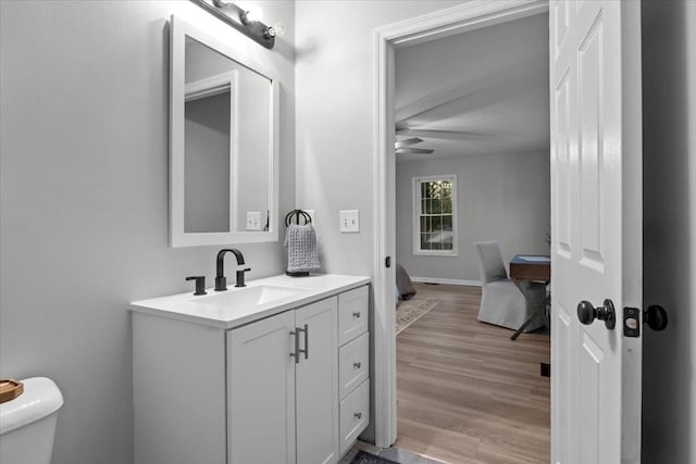 bathroom featuring toilet, wood finished floors, and vanity