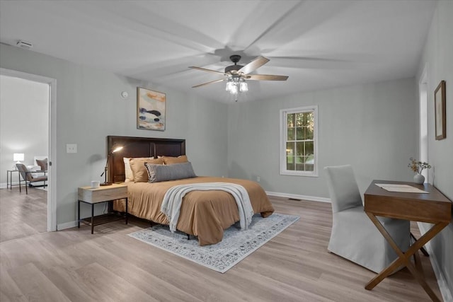 bedroom with ceiling fan, wood finished floors, and baseboards