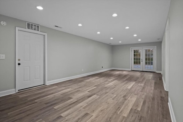 empty room featuring french doors, visible vents, and wood finished floors