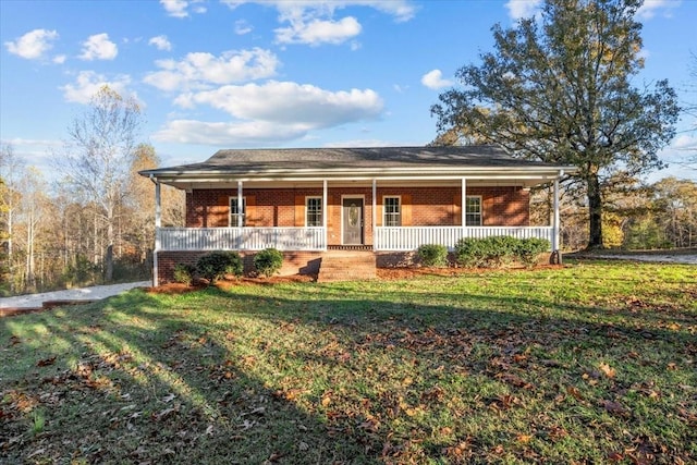 ranch-style home featuring covered porch, brick siding, and a front yard