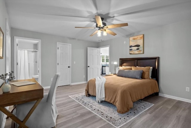 bedroom featuring light wood-style flooring, baseboards, ceiling fan, and connected bathroom