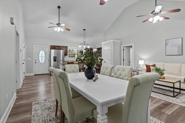 dining room with dark wood-type flooring, high vaulted ceiling, and a ceiling fan