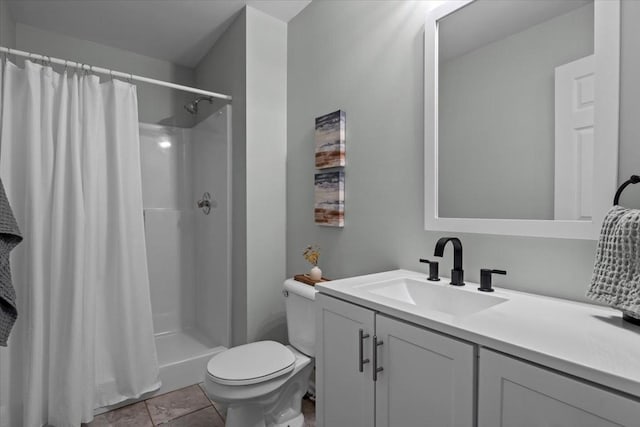 bathroom featuring a shower stall, toilet, and vanity