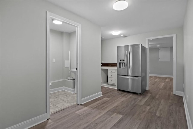 kitchen with baseboards, wood finished floors, and stainless steel fridge with ice dispenser