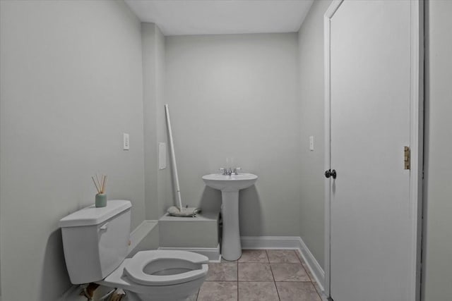 bathroom with baseboards, a sink, toilet, and tile patterned floors