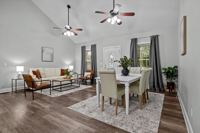 dining room featuring dark wood-style floors, high vaulted ceiling, and a healthy amount of sunlight