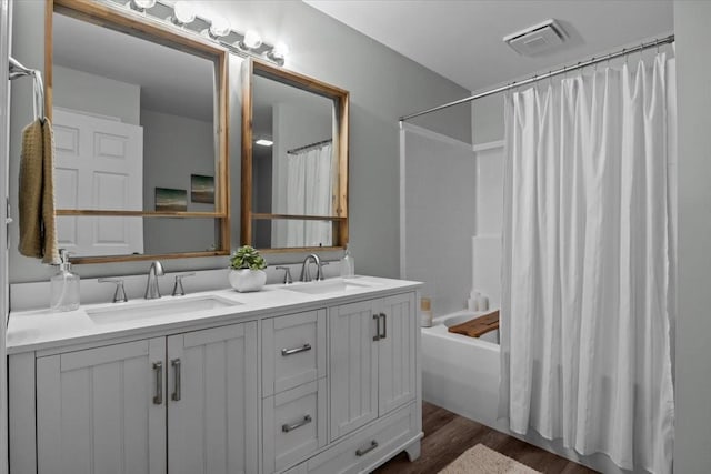 bathroom featuring shower / tub combo with curtain, visible vents, a sink, and double vanity