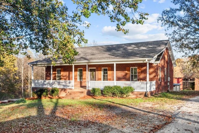 ranch-style home featuring a porch and brick siding