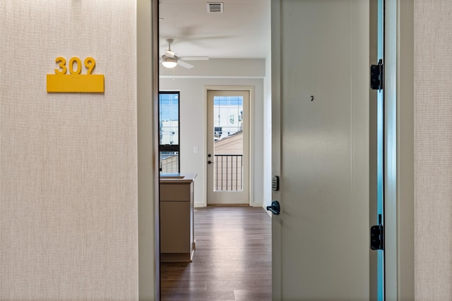 hallway featuring baseboards, visible vents, and dark wood-type flooring