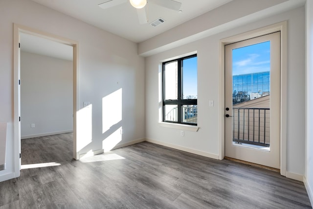 interior space featuring a ceiling fan, wood finished floors, visible vents, and baseboards