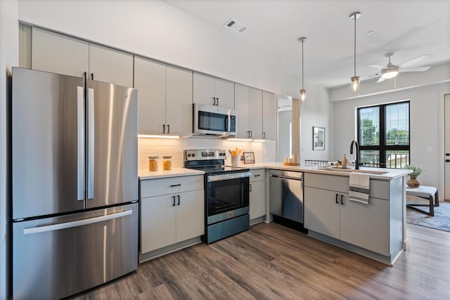 kitchen with a peninsula, visible vents, stainless steel appliances, and gray cabinetry