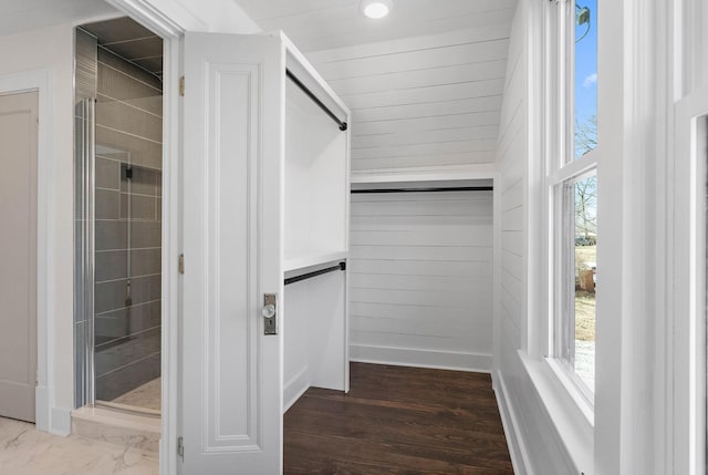 walk in closet with wood finished floors