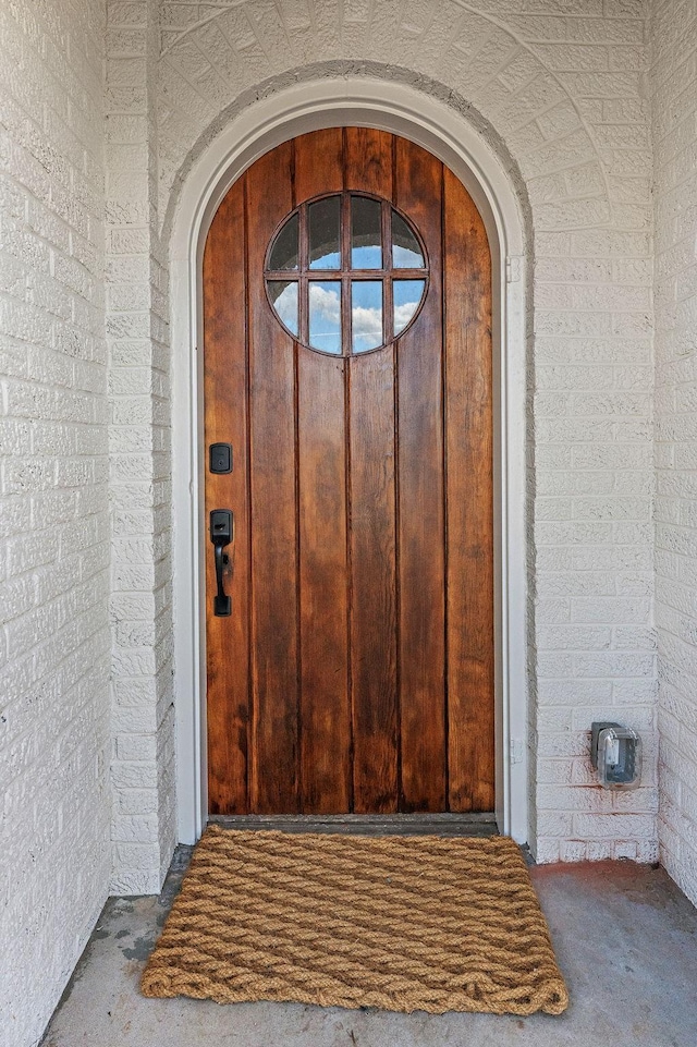 doorway to property with brick siding