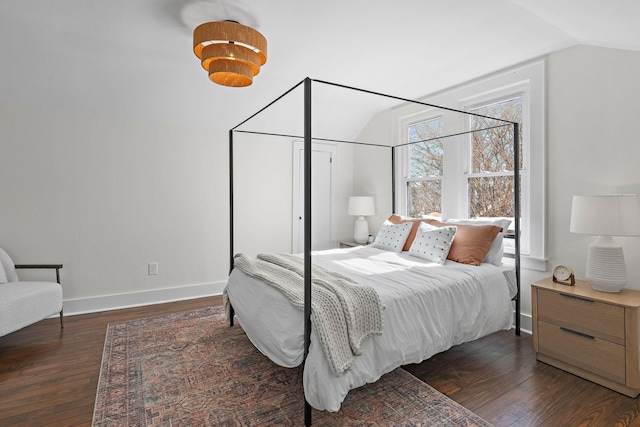 bedroom featuring lofted ceiling, baseboards, and wood finished floors