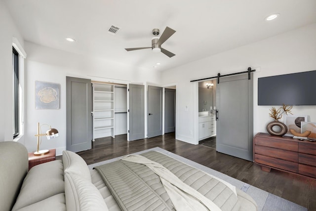 bedroom with recessed lighting, visible vents, dark wood finished floors, and a barn door