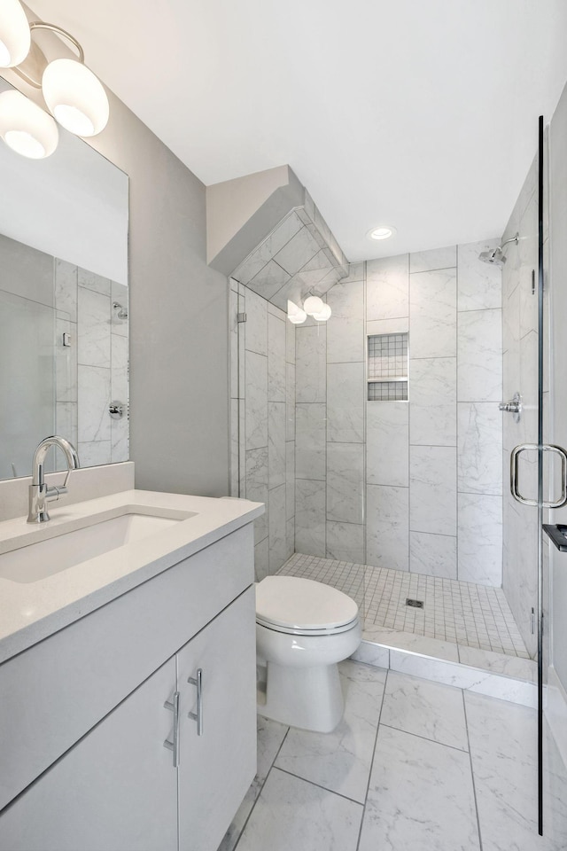 full bathroom with marble finish floor, vanity, a shower stall, and toilet