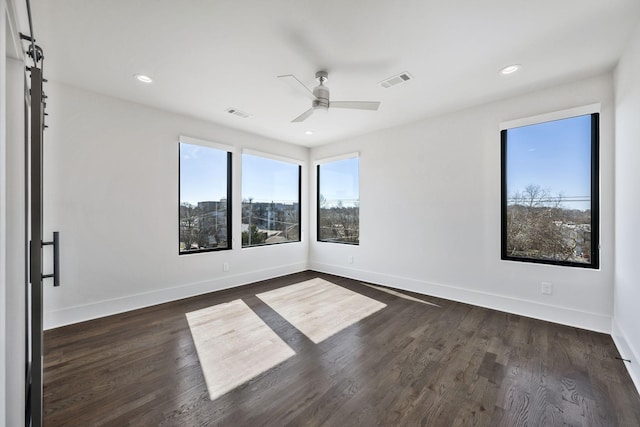 empty room with recessed lighting, a ceiling fan, visible vents, baseboards, and dark wood finished floors