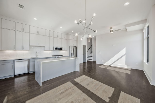 kitchen featuring stainless steel appliances, light countertops, visible vents, and tasteful backsplash