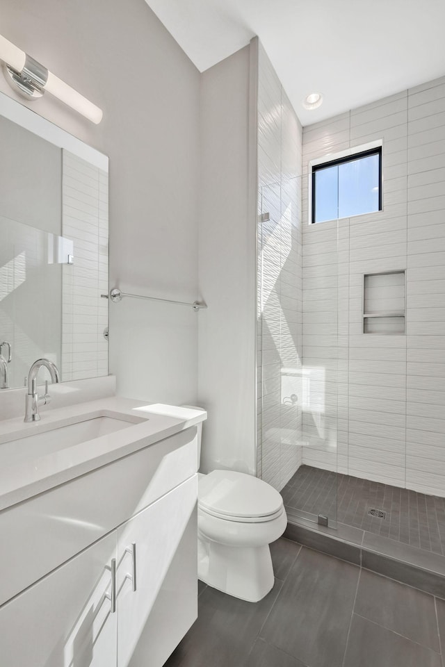 full bathroom featuring a stall shower, vanity, toilet, and tile patterned floors