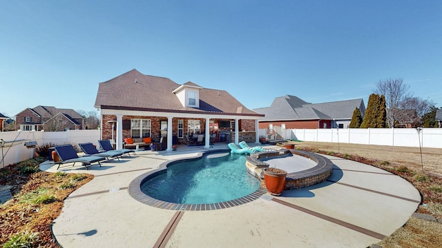 view of swimming pool featuring a patio area, a fenced backyard, and a pool with connected hot tub