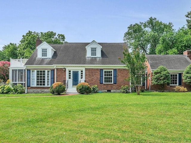 new england style home featuring roof with shingles, a chimney, a front lawn, and brick siding