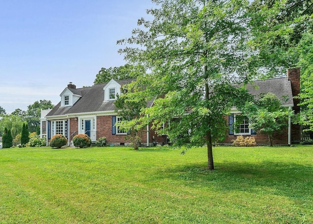 cape cod house with roof with shingles, brick siding, a chimney, and a front lawn