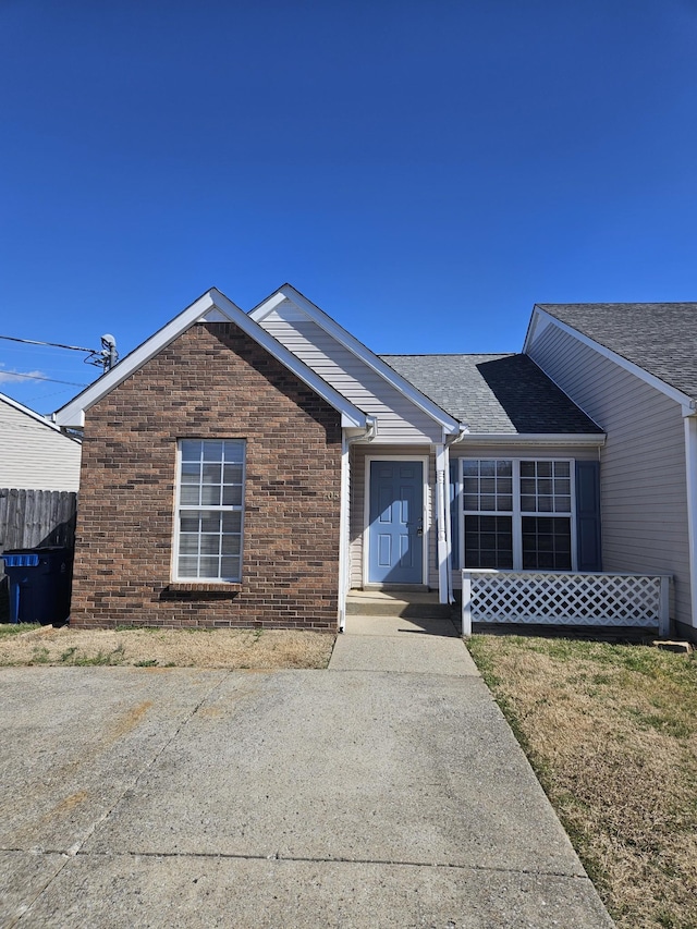 ranch-style home featuring brick siding and fence