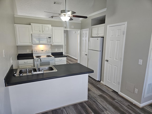 kitchen with white appliances, dark countertops, visible vents, and white cabinets