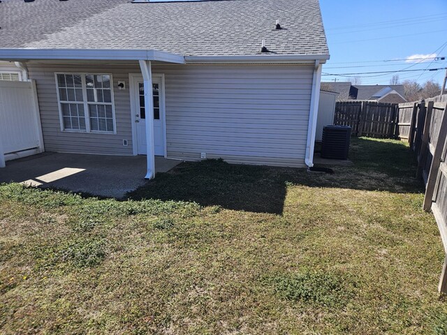 back of house with a yard, a shingled roof, a patio, and a fenced backyard