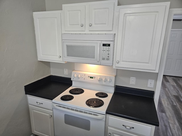 kitchen featuring white appliances, dark wood-style flooring, dark countertops, and white cabinetry