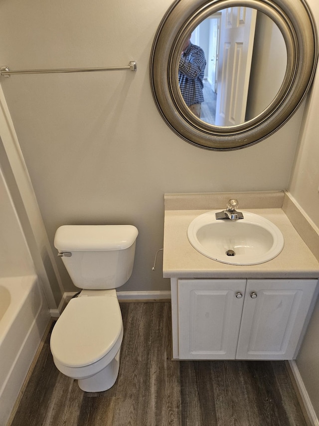 bathroom featuring vanity, wood finished floors, toilet, and baseboards