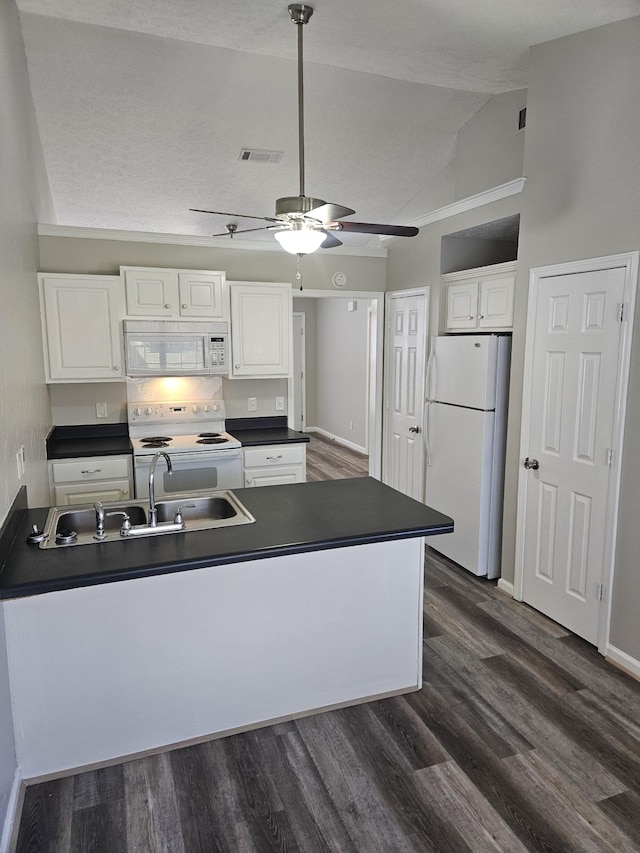 kitchen featuring dark wood-style flooring, dark countertops, visible vents, white cabinets, and white appliances