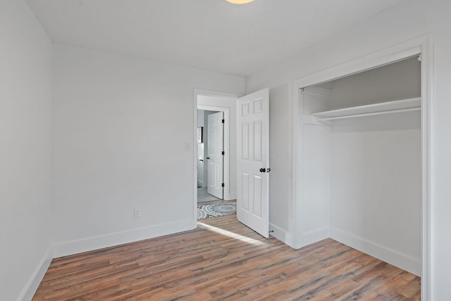 unfurnished bedroom with baseboards and wood finished floors