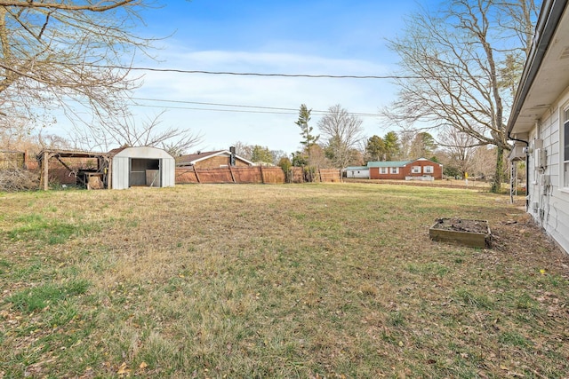 view of yard featuring a storage shed, fence, and an outdoor structure