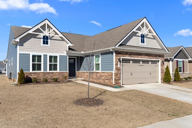 craftsman-style home featuring stone siding, roof with shingles, and concrete driveway