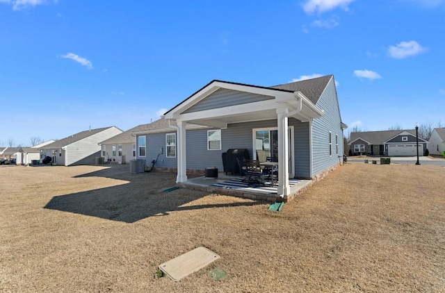 back of house featuring a patio, cooling unit, and a residential view