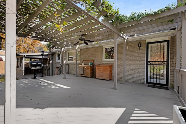 deck featuring ceiling fan, a grill, and a pergola