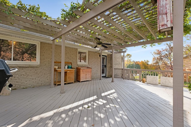 wooden deck with a ceiling fan, grilling area, and a pergola