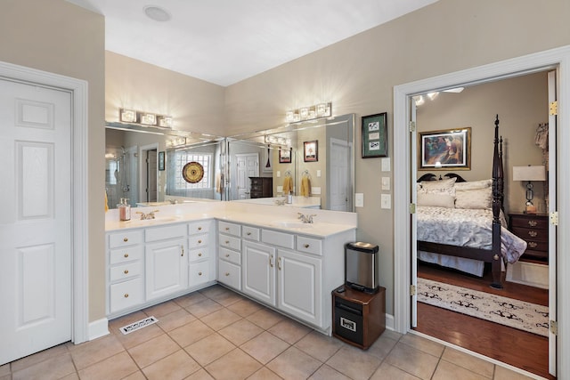 ensuite bathroom featuring double vanity, visible vents, ensuite bathroom, a sink, and tile patterned flooring