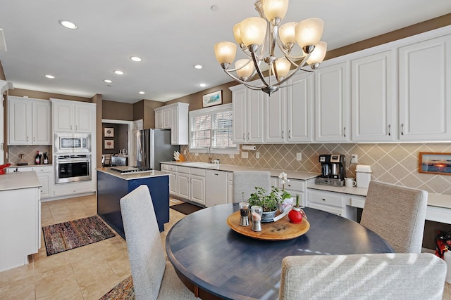 dining room featuring a chandelier, light tile patterned flooring, and recessed lighting