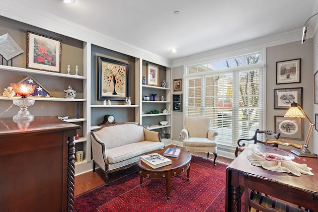 sitting room featuring built in features, dark wood-style flooring, and crown molding