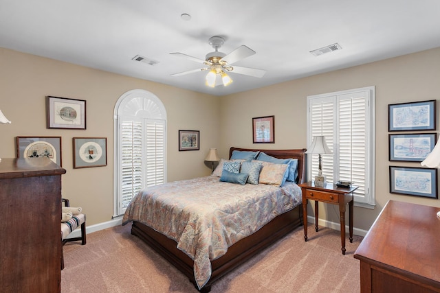 bedroom with light carpet, multiple windows, visible vents, and baseboards