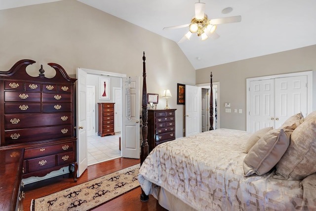 bedroom featuring lofted ceiling, a closet, wood finished floors, and a ceiling fan