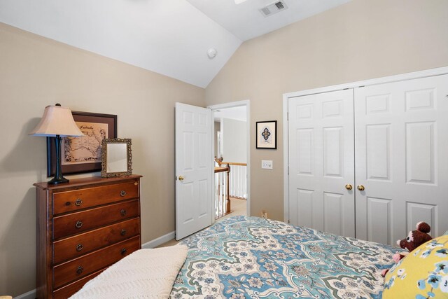 bedroom featuring vaulted ceiling, a closet, visible vents, and baseboards